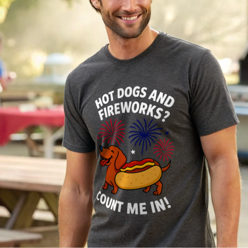 Man wearing a t-shirt with a hot dog and fireworks design outdoors.