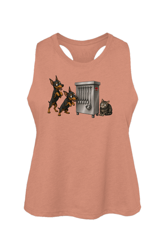 A women's sleeveless racerback tank top in a muted peach-pink color, featuring a graphic print of two Doberman dogs and a cat interacting with a silver electric space heater on a white background.