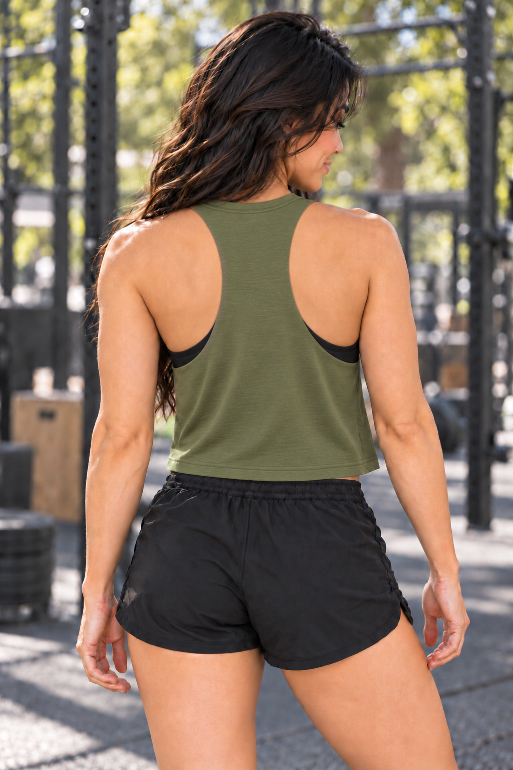 Grace wearing Boop Apparel Big Dog Energy Bella+Canvas 6682 crop tank in Heather Olive, back view at an outdoor gym.