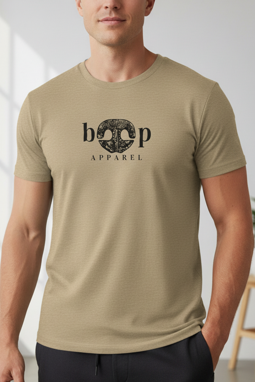 Athletic male model wearing a heather tan crew neck t-shirt featuring the Boop Apparel logo — iconic dog nose design where a dog's nose forms the O's in Boop. A stylish, comfortable everyday tee for dog lovers. Part of the Boop Apparel Everyday T collection.