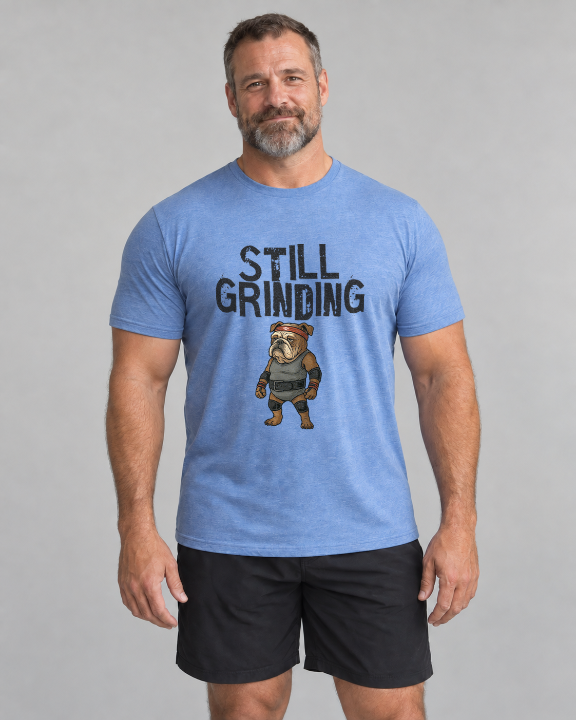 Ed wearing Still Grinding Everyday T in Heather Columbia Blue, studio front view